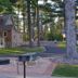 Amber's Inn & Suites in Wisconsin Dells with picnic tables, fire pit, and wooded roadside setting