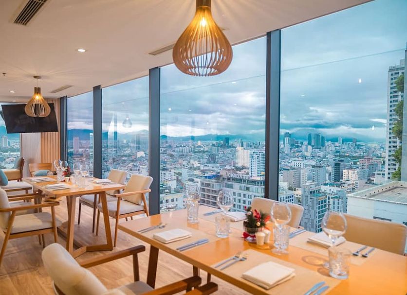 Tms Hotel Da Nang Beach in Da Nang dining room with city and mountain views through floor-to-ceiling windows