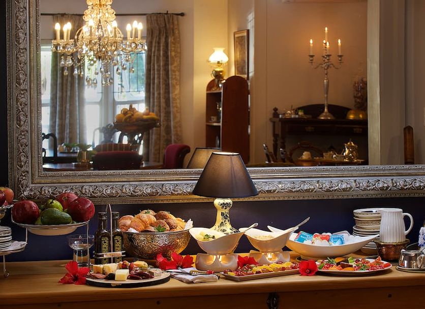 Breakfast buffet at Batavia Boutique Hotel in Stellenbosch with pastries, fruit, and coffee on a table