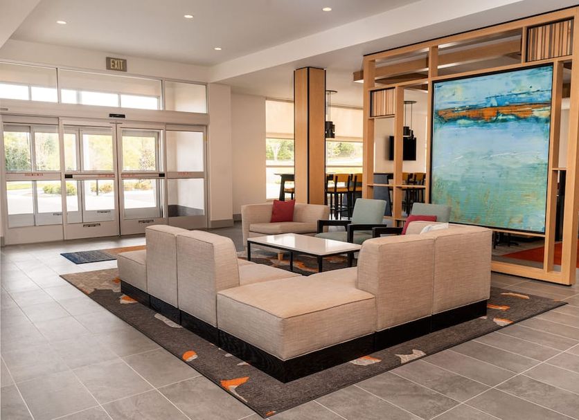 Hyatt House Nashville Airport lobby with sectional seating, tables, and large artwork in Nashville
