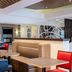 Holiday Inn Express & Suites Chicago-Libertyville lobby seating area with tables, booth, and coffee station
