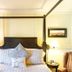 The Stella Rose B&b in Wolfville: four-poster bed with striped chairs and bedside lamps