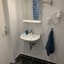 Bathroom at Zum armen Mann in Düsseldorf with sink, mirror, wall-mounted hair dryer and towel rack