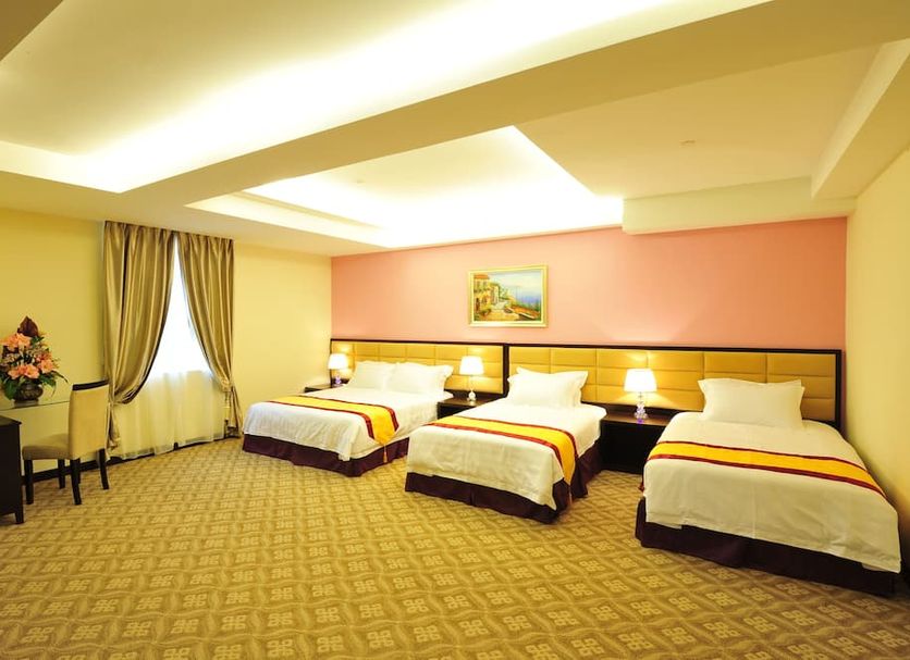 Hallmark Regency Hotel Johor Bahru room with three single beds and warm lighting