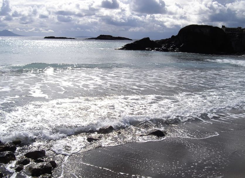 Fourtounis Hotel in Kefalos with a rocky beach and ocean waves under a cloudy sky