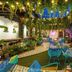 Adra Hostel in Antigua courtyard with hanging greenery, string lights, lounge seating and colorful stairs