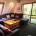 Haka Lodge Christchurch lounge with sectional sofa, coffee table, large windows and garden view