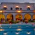 La Piana degli Ulivi in Ostuni with a lit outdoor pool and arched terrace at dusk