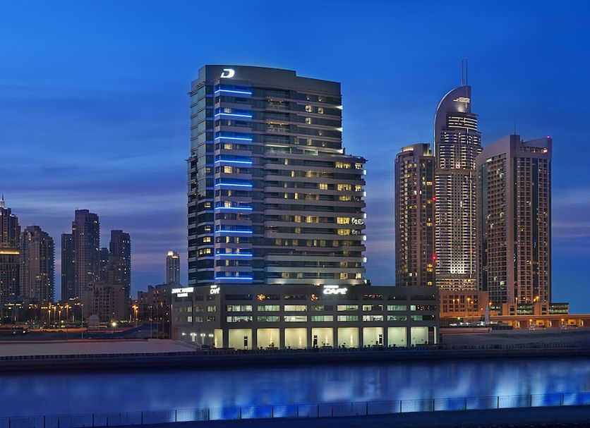 DAMAC Maison Canal Views in Dubai at dusk, with illuminated towers and canal-side skyline view