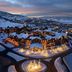 Waldorf Astoria Park City snowy mountain resort at dusk with lit lodges and winding roads