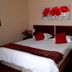 Oak Rest Guesthouse in Kimberley room with twin beds, red accents, and floral wall art