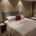 Wanhao International Hotel in Benxi guest room with double bed, sofa, and soft lighting