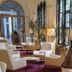 Kardinal Schulte Haus lounge in Bergisch Gladbach with white chairs, tall windows and potted plants