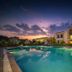 Jungle Vilas in Sawāi Mādhopur with a turquoise outdoor pool beside the hotel at sunset