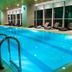 Indoor pool at The Landmark Hotel in Baku with lounge chairs and large windows