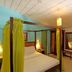 Sobrado da Vila Hotel in Mata de São João with a canopy bed and warm, colorful bedroom interior