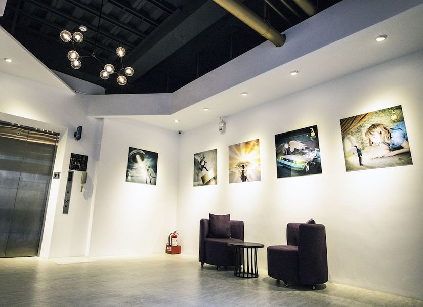 Time Flyer Hotel in Taichung City lobby with white walls, elevator, black chairs and framed art