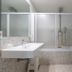 Grand Hotel Salerno bathroom with sink, bathtub shower, frosted glass screen and toilet