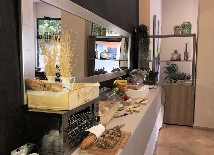 Apartamentos Plaza Picasso Valencia breakfast buffet with pastries, fruit, and drinks in dining area