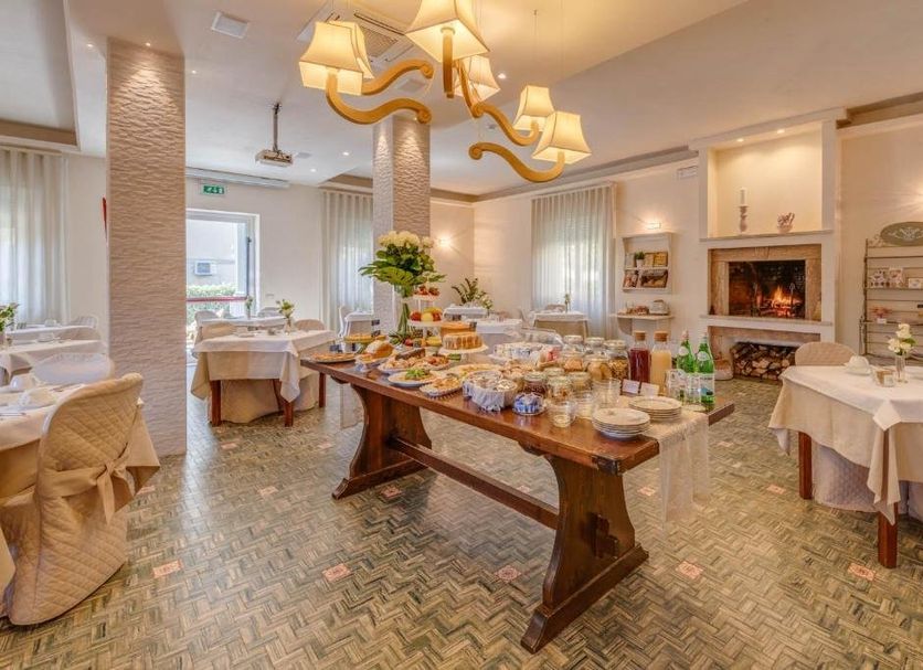Hotel Massimo in Cecina breakfast room with buffet table and fireplace