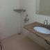 Hotel Rajmata Pvt Ltd Hyderabad bathroom with shower, sink, mirror, and wall shelf