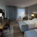 Maritim Hotel Bremen guest room in Bremen with two beds, desk, lamps, and window curtains