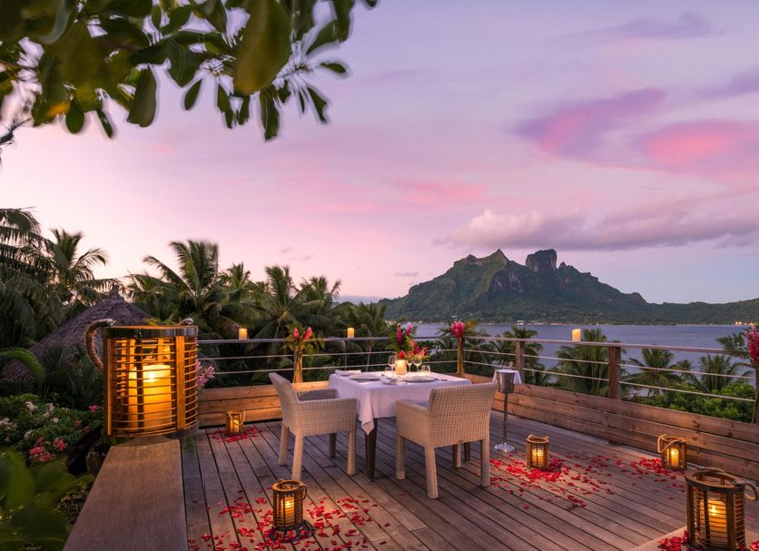 Conrad Bora Bora Nui in Vaitape: seaside terrace dining with sunset views over the lagoon and island