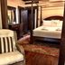 Park Plaza Hotel in Winter Park guest room with four-poster bed, patterned rug and wicker chair