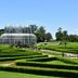 Pestana Curitiba in Curitiba with landscaped hedge garden and glass conservatory under blue sky