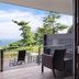 Atami Club Geihinkan in Atami with a hanging chair and balcony seating overlooking the ocean