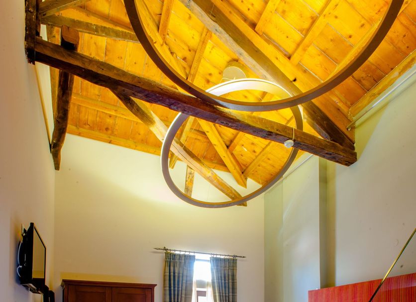 Splanzia Boutique Hotel in Chania: cozy room with wood-beam ceiling, bed, wardrobe, and window curtains