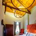 Splanzia Boutique Hotel in Chania: cozy room with wood-beam ceiling, bed, wardrobe, and window curtains