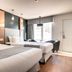 Hotel Marineau Shawinigan guest room with two beds, wood floors, and balcony doors in Shawinigan