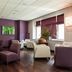 Les Thermes de l'Avenue in Dax lounge with purple seating, wall TV, and large windows