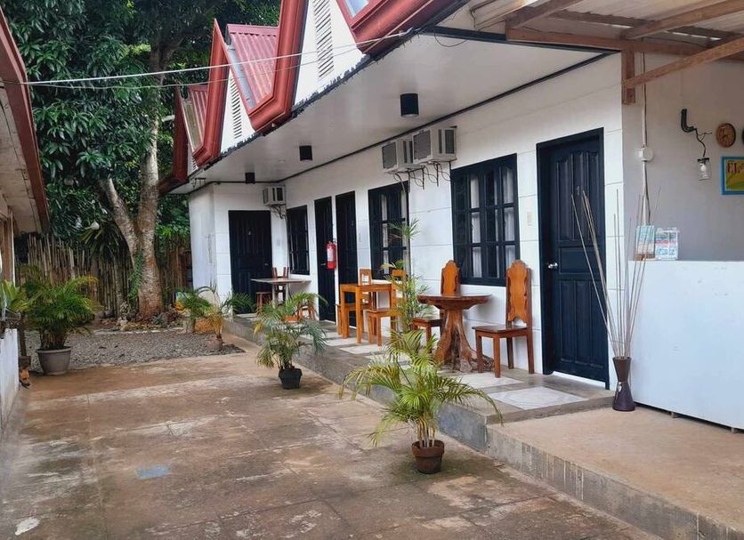 El Taraw Bed And Breakfast in Puerto Princesa courtyard with outdoor seating and guest room doors