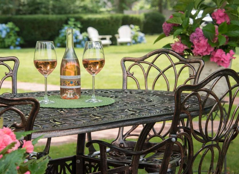Captain Farris House in South Yarmouth with wine glasses and bottle on an outdoor patio table