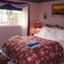 The Grateful Bed B'nB in Prince George bedroom with floral bedspread, window, lamp and wall art