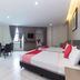 Hotel Suria Malaqa in Malacca: bright guest room with two beds, dining table, windows and curtains