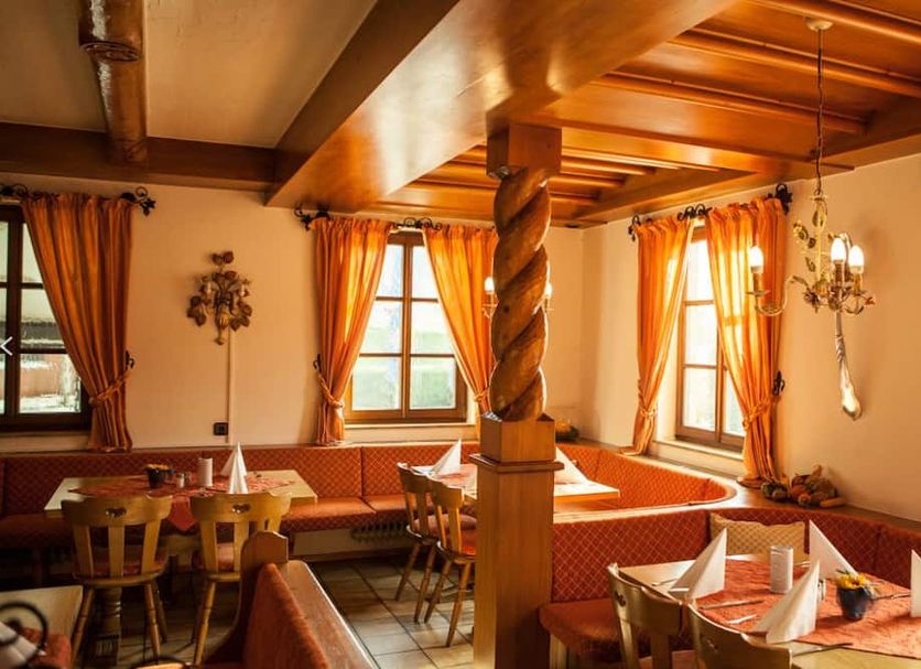 Hotel Seltenbacher Hof in Tuttlingen restaurant with orange curtains and wood beams