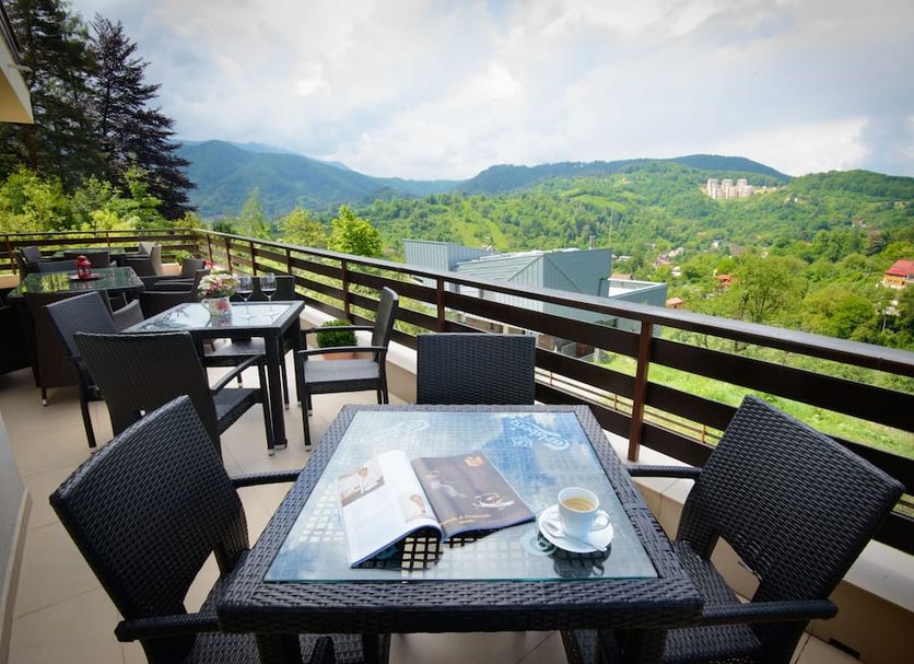 Pensiunea Toscana terrace with table and chairs overlooking Braşov mountains and valley