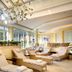 Hotel Bareiss in Baiersbronn lounge with sunlit lounge chairs and large windows overlooking the mountains
