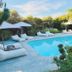 Sovn Experience+Lifestyle Cape Town poolside lounge with umbrellas, daybeds and lush garden