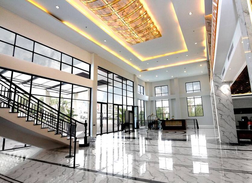 Hermes Palace Hotel Banda Aceh lobby with marble floors, grand staircase, and tall windows