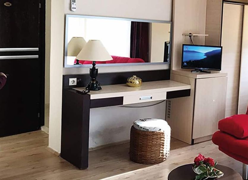 Rumana Hotel in Anamur, guest room with vanity desk, mirror, TV, and red armchair