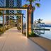 Onyx Rotana in Manama: illuminated palm-lined walkway beside an infinity pool at sunset