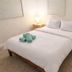 La Mare Fort Lauderdale Airport guest room with a neatly made bed, bedside lamps, and rolled towels