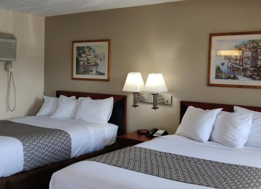 Sandusky Inn in Sandusky guest room with two double beds, wall art, and bedside lamps