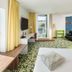 Ibis Styles Wien City room in Vienna with bed, TV, sofa, and balcony door to city view