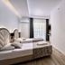 Grand Uysal Apart Hotel Alanya twin bedroom with balcony door, arched headboards and wood flooring