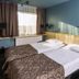 Ibis Styles Riga twin room with two single beds, window light, and blue walls